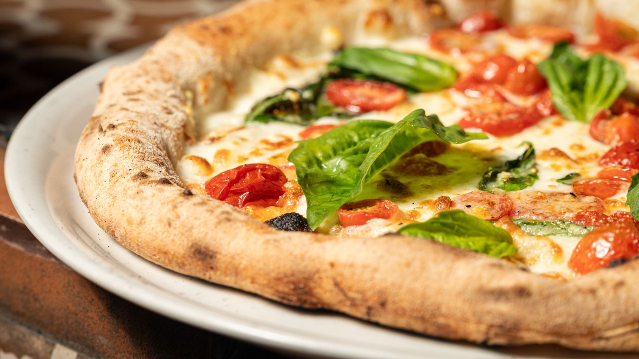 Delicious homemade Margarita pizza topped with fresh basil and cherry tomatoes.